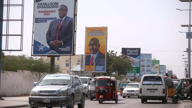 Motorists drive along a street with the campaign billboards of Somalia's Presidential candidates in Somalia's capital Mogadishu, Feb. 6, 2017.